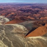 Sie wirken wie beigefarbene Wellen am roten Strand, doch es sind nur die Ablagerungen eines längst verdunstetem Flusses. Nur in besonders niederschlagsreichen Regenzeiten schafft es das Wasser aus den 150 Kilometer entfernten Naukluftbergen bis hier ins Große Sandmeer