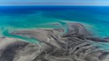Der Tidenhub hier beträgt bis zu zehn Meter weswegen sich bei Ebbe das Wasser kilometerweit zurückzieht. Zu sehen ist dann grauer Schlick, der sonst von türkisem Wasser bedeckt ist 
