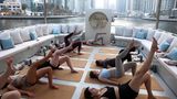 Dubai, Vereinigte Arabische Emirate. Wenn man sich schon der mühseligen Fitnessarbeit hingibt, dann wenigstens in ansprechender Umgebung. Auf einer Luxusyacht in der Wüstenmetropole hebt sich das Bein leichter