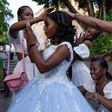 Freunde und Familie umsorgen eine 15-Jährige, die ihre "Quinceañera" feiert – ein traditionelles Fest zum 15. Geburtstag eines Mädchens in Lateinamerika. Es symbolisiert den Übergang von der Kindheit zum Erwachsenwerden und stellt die offizielle Einführung der jungen Frau in die Gesellschaft dar. Die Aufnahme entstand, als sich die junge Frau auf ihre Fotosession auf der Plaza Colón im Stadtteil Zona Colonial in Santo Domingo vorbereitete