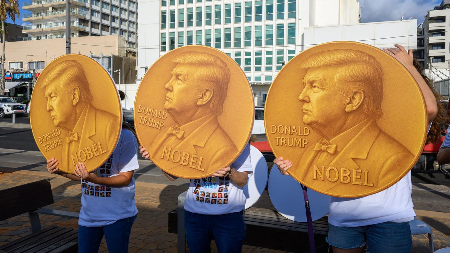 Demonstranten halten selbstgemachte Friedensnobel-Preismedaillen mit dem Bildnis von Donald Trump hoch