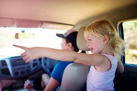 Kinder im Auto: Ein Mädchen zeigt aus dem Fenster