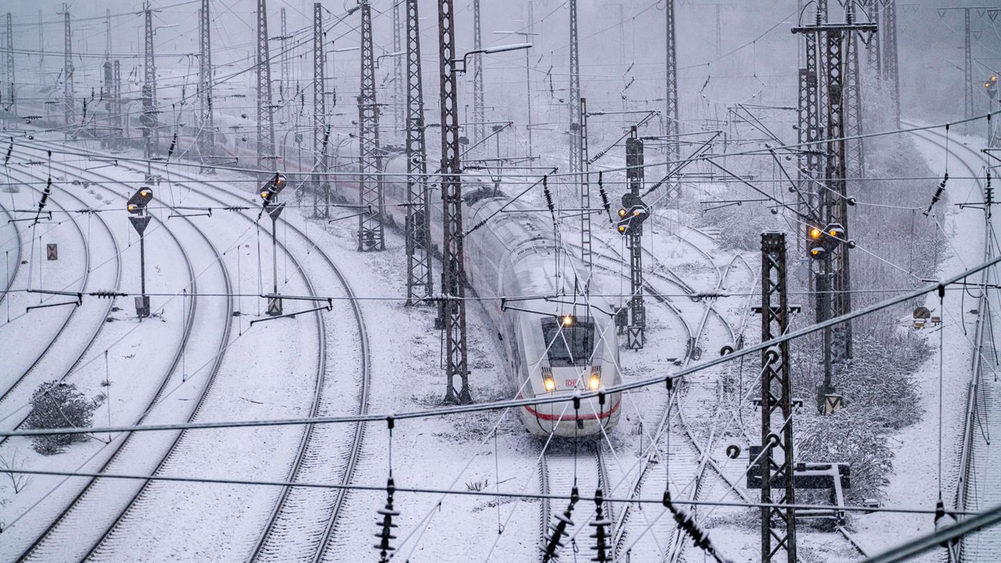Ein ICE der Deutschen Bahn im fährt im Winter über verschneite Gleise