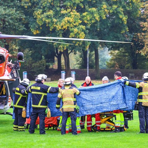 Einsatzkräfte stehen neben einem Rettungshubschrauber