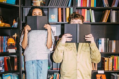 Unnützes Wissen: Zwei Menschen mit Büchern in den Händen.