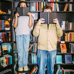 Unnützes Wissen: Zwei Menschen mit Büchern in den Händen.