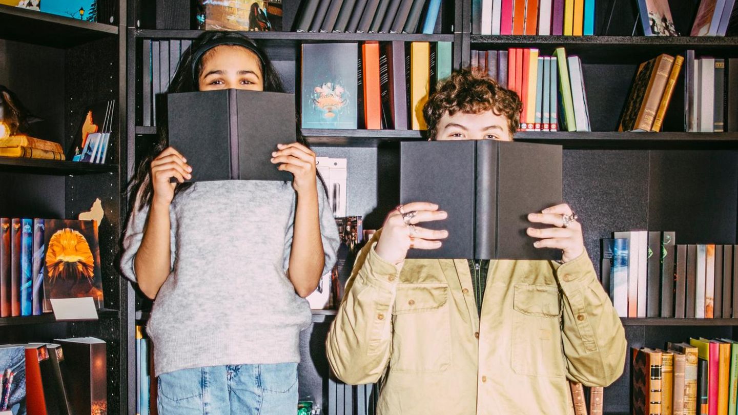 Unnützes Wissen: Zwei Menschen mit Büchern in den Händen.
