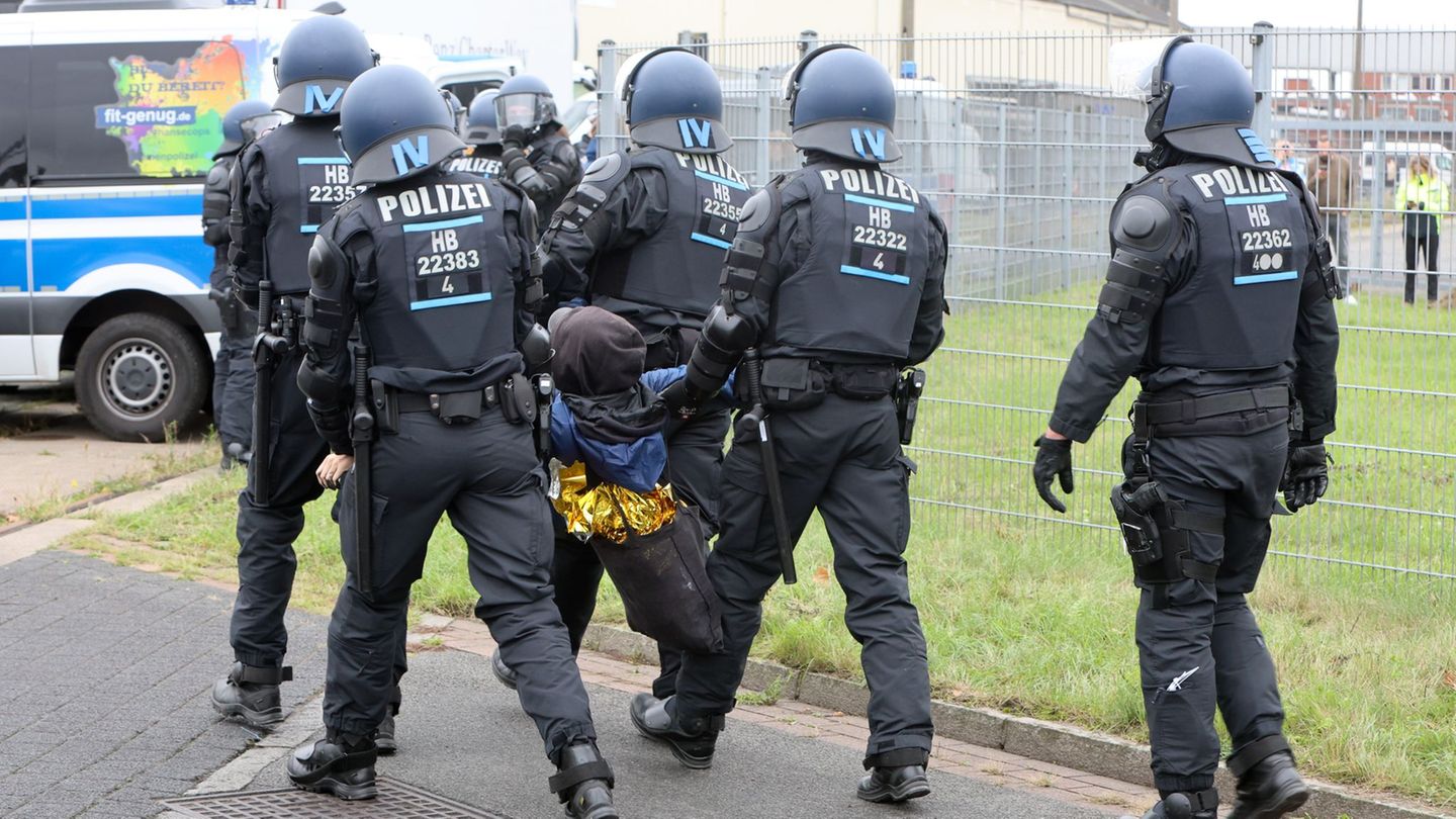 Weil sie ihre Vermummung nicht ablegen wollten, sind einige Protestierende weggetragen worden. Foto: Christian Butt/dpa