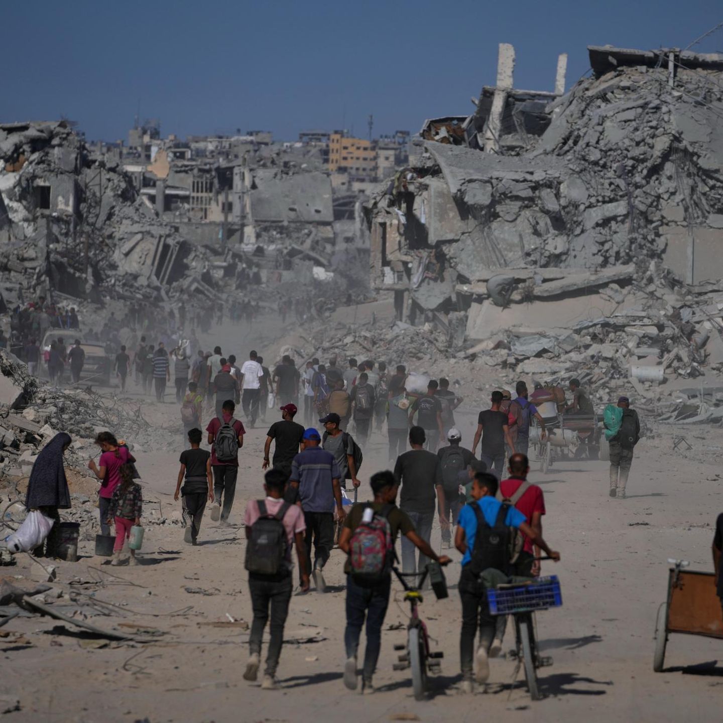 Palästinenser gehen an zerstörten Gebäuden vorbei, während sie in ihre Häuser im Zeitoun-Viertel von Gaza zurückkehren