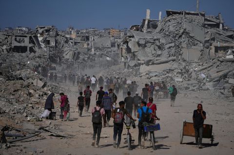 Palästinenser gehen an zerstörten Gebäuden vorbei, während sie in ihre Häuser im Zeitoun-Viertel von Gaza zurückkehren