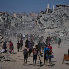 Palästinenser gehen an zerstörten Gebäuden vorbei, während sie in ihre Häuser im Zeitoun-Viertel von Gaza zurückkehren
