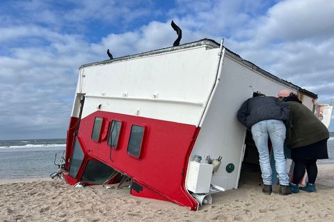 Schaulustige schauen sich auf Sylt einen angespülten Bootsaufbau an. Foto: Lea Albert/dpa