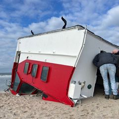 Schaulustige schauen sich auf Sylt einen angespülten Bootsaufbau an. Foto: Lea Albert/dpa