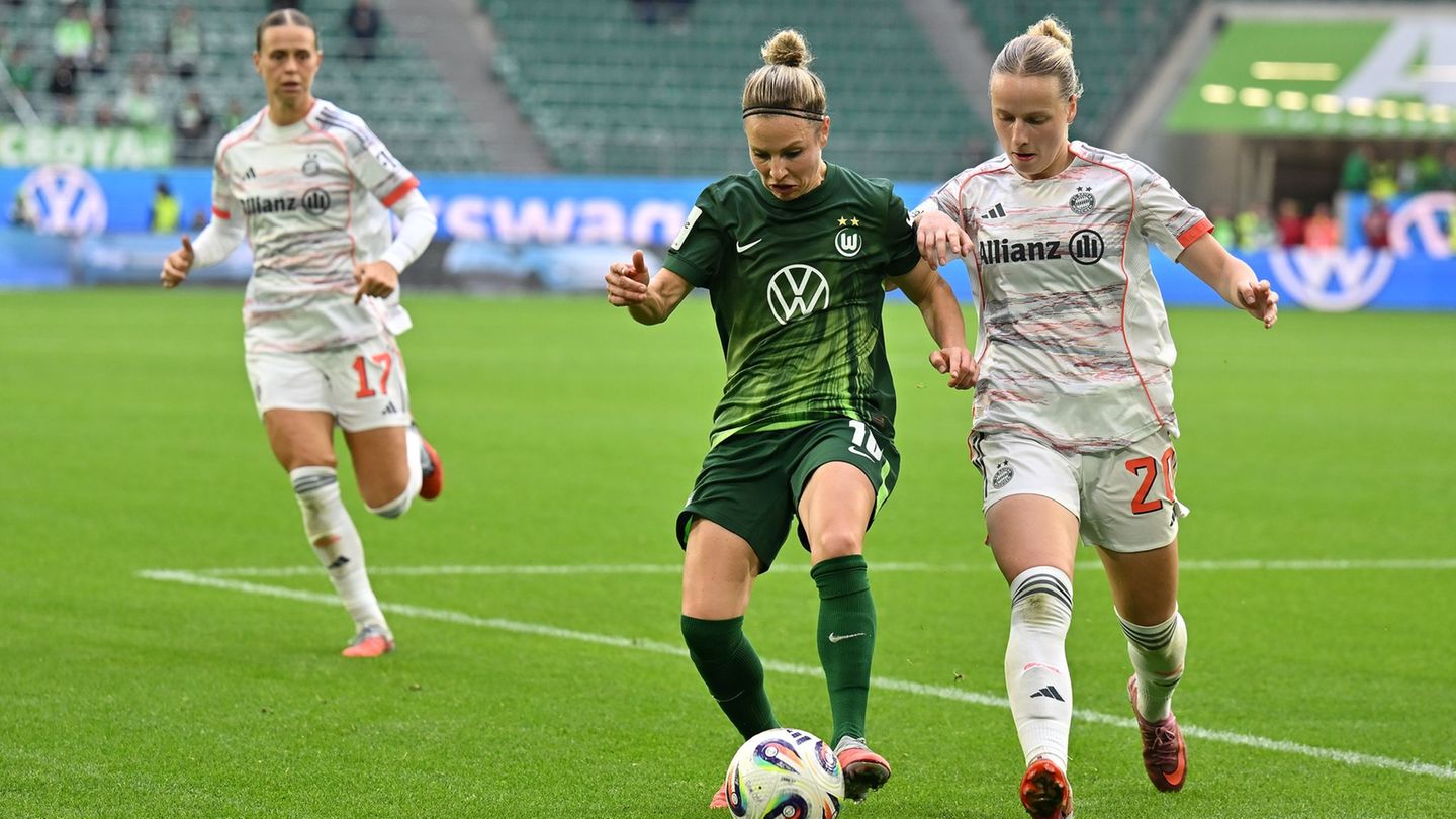 Wolfsburgs Svenja Huth (M) im Zweikampf mit Franziska Kett vom FC Bayern München. Foto: Swen Pförtner/dpa