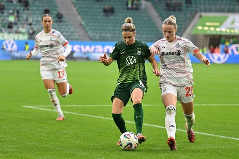 Wolfsburgs Svenja Huth (M) im Zweikampf mit Franziska Kett vom FC Bayern München. Foto: Swen Pförtner/dpa