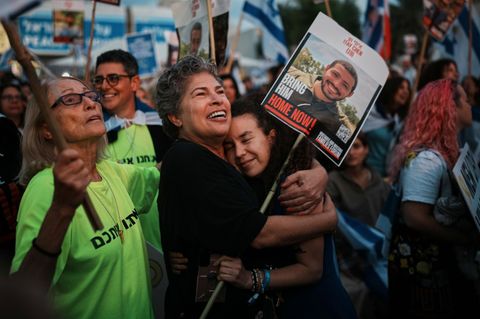 Menschen liegen sich in Tel Aviv vor der Geiselfreilassung in den Armen