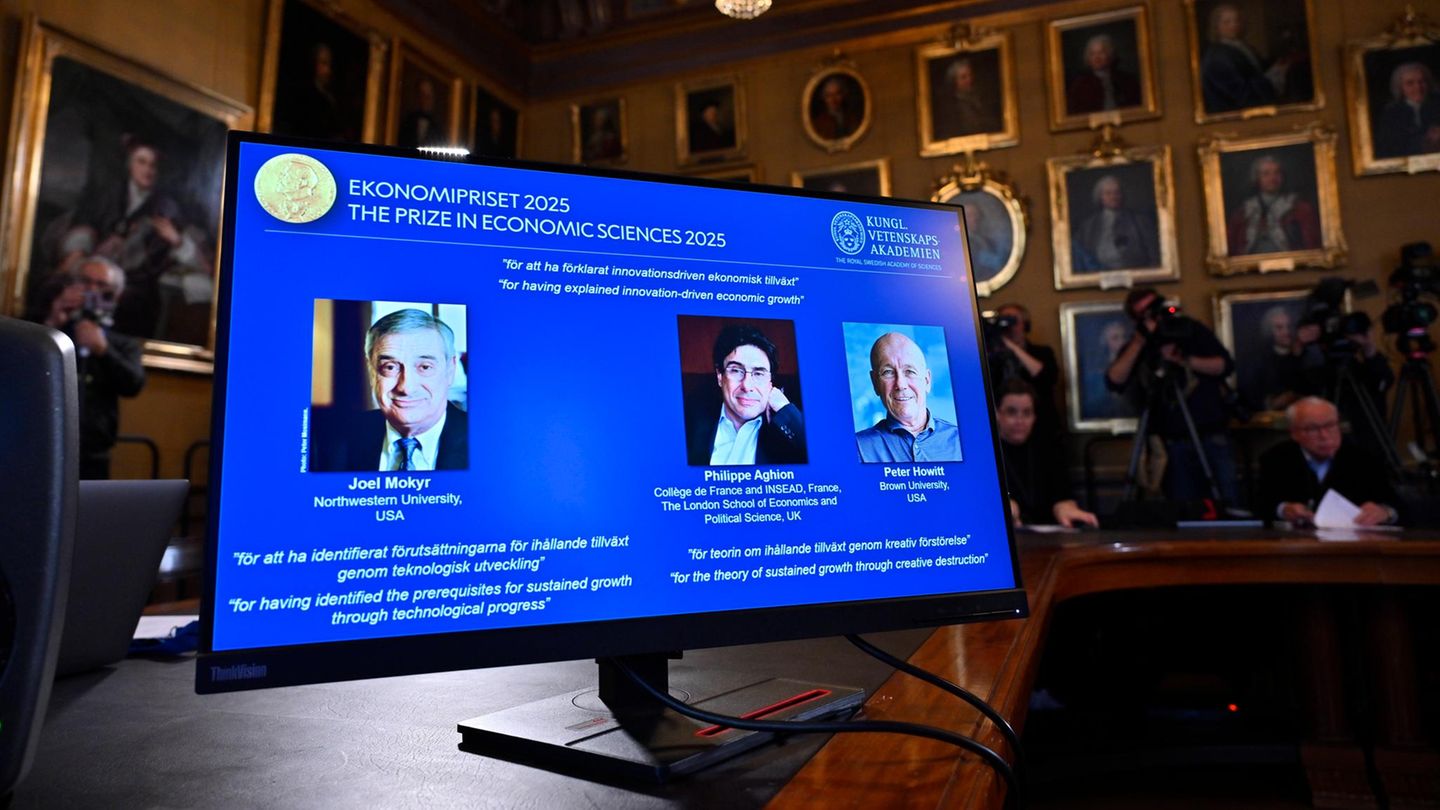 Ein Bildschirm bei der Verleihung des Nobelpreises für Wirtschaft zeigt Joel Mokyr, Philippe Aghion und Peter Howitt