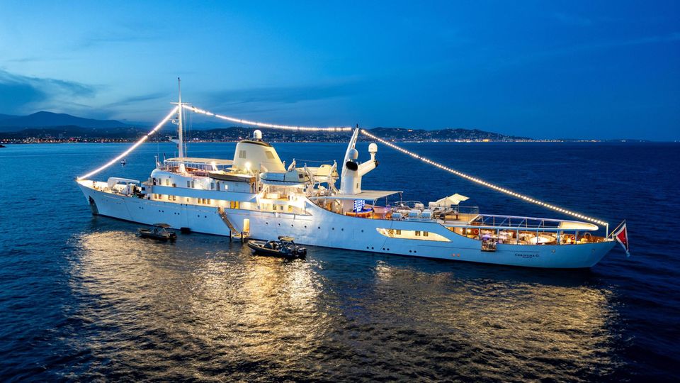 Die Yacht Christina O. vor der Küste, beleuchtet von Lichterketten Die Yacht Christina O. vor der Küste, beleuchtet von Lichterketten