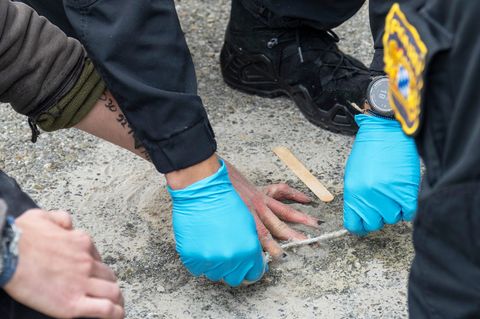 Speziell geschulte Polizisten versuchten, die Hände von Demonstranten von der Straße zu lösen. Foto: Stefan Puchner/dpa