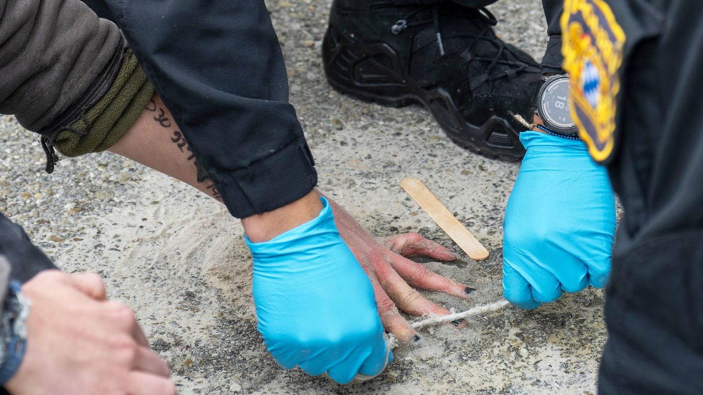 Speziell geschulte Polizisten versuchten, die Hände von Demonstranten von der Straße zu lösen. Foto: Stefan Puchner/dpa