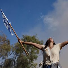 Frau freut sich mit israelischer Fahne über die Freilassung der Geiseln aus Gaza