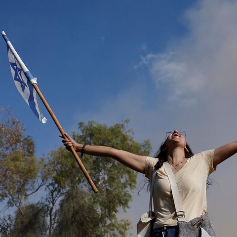 Frau freut sich mit israelischer Fahne über die Freilassung der Geiseln aus Gaza
