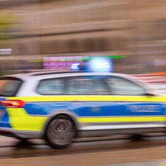 Ein Polizeiauto fährt mit Blaulicht zum Einsatzort