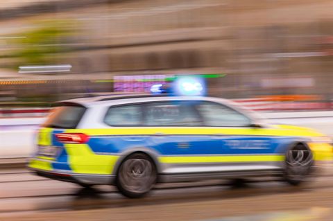 Ein Polizeiauto fährt mit Blaulicht zum Einsatzort