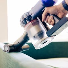 Person nutzt Dyson Handstaubsauger