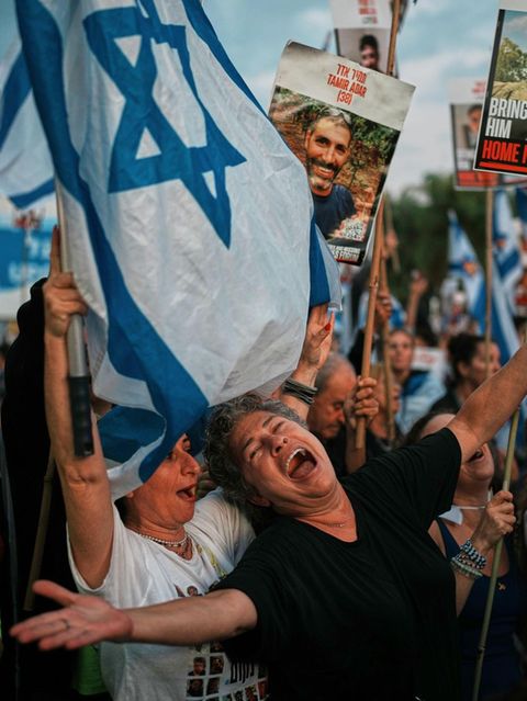 Israelis im Zentrum von Tel Aviv, sie halten Schilder und die Israelflagge hoch. Gaza Geiseln