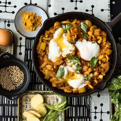 Eine Pfanne mit gelbem Ratatouille und Onsen-Eiern