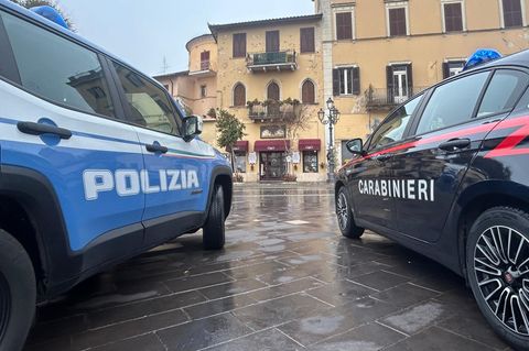 Zwei Autos der italienischen Einsatzkräfte (Polizei und Carabinieri) stehen vor einem Gebäude