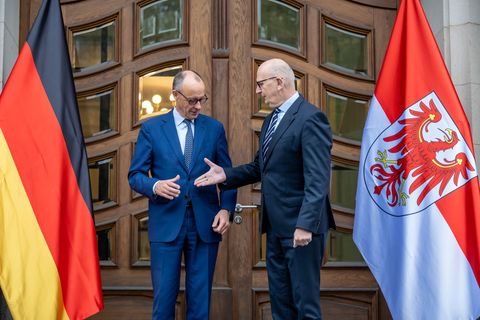 "Shake hands" zum Auftakt: Kanzler Merz (CDU) wird vom brandenburgischen Ministerpräsidenten Dietmar Woidke (SPD) empfangen. Es