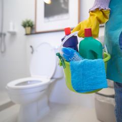 Person putzt Toilette