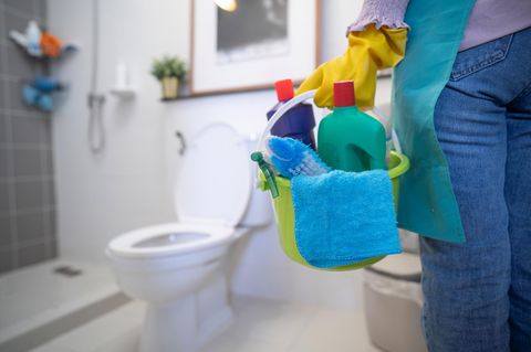 Person putzt Toilette