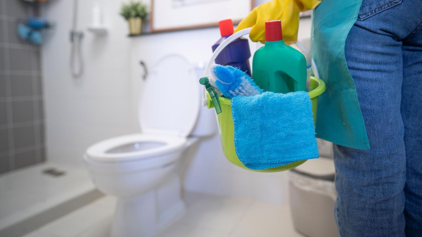 Person putzt Toilette