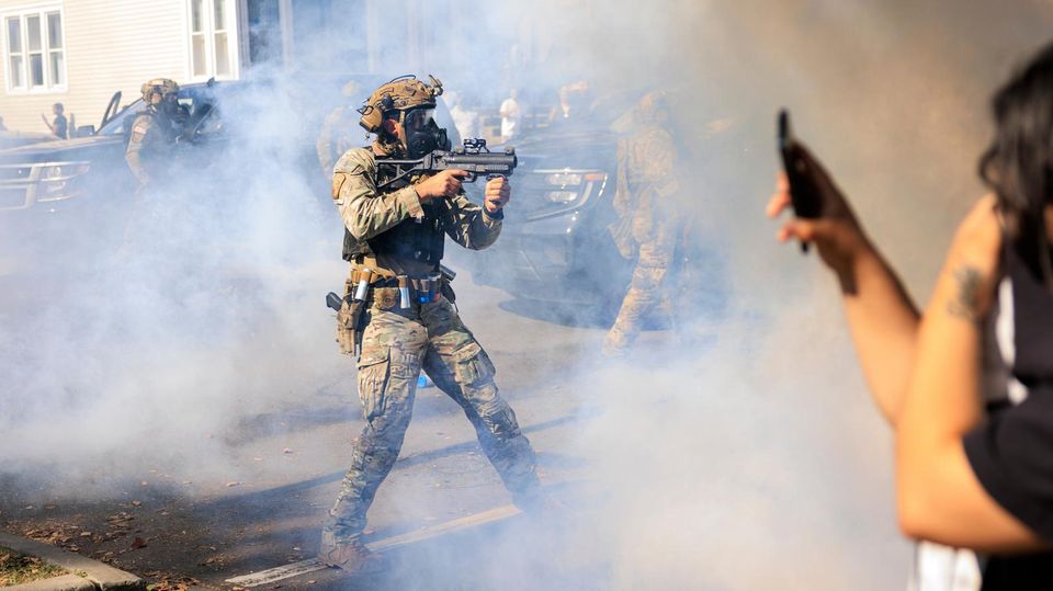 Nach Flucht: Chaos und Festnahmen in Chicago Bewaffnete US-Polizisten und Grenzschutzbeamte stehen Zivilisten gegenüber