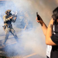 Bewaffnete US-Polizisten und Grenzschutzbeamte stehen Zivilisten gegenüber