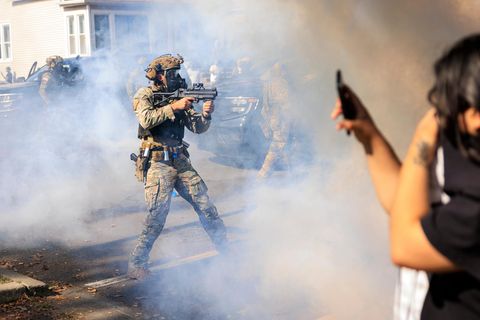 Bewaffnete US-Polizisten und Grenzschutzbeamte stehen Zivilisten gegenüber