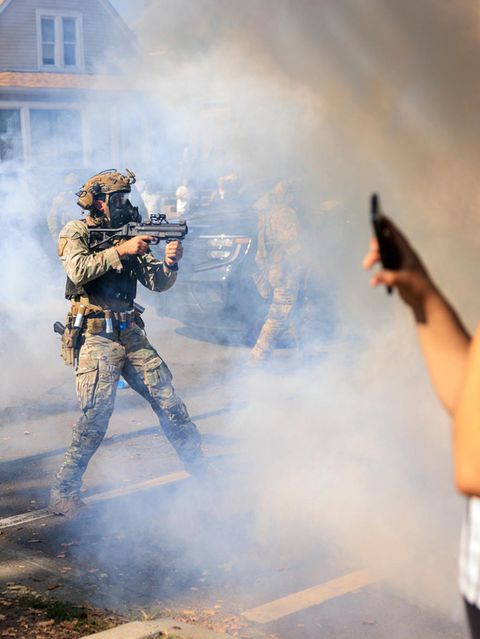 Bewaffnete US-Polizisten und Grenzschutzbeamte stehen Zivilisten gegenüber