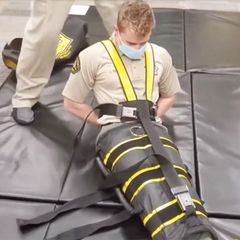 ICE-Agenten präsentieren die umstrittene Ganzkörperfessel "The Wrap"