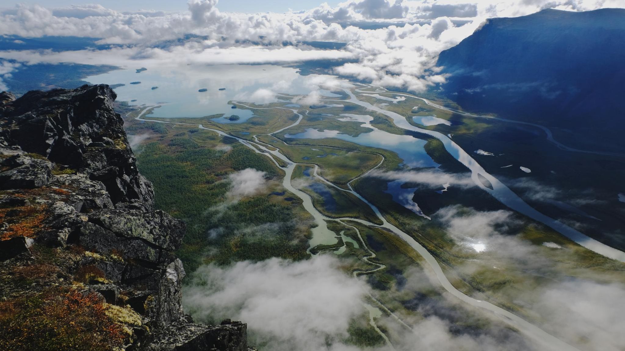 Unter löchrigen Wolkendecke ist ein verzweigtes Flussdelta zu sehen: das Laitaure-Delta