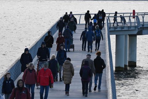 Auch bei herbstlichem Wetter spazieren Touristen gern über die Seebrücke in Prerow. Foto: Stefan Sauer/dpa