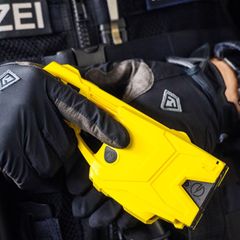Ein Polizeibeamter hält einen Taser