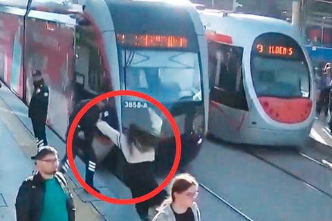 Unaufmerksame Frau läuft vor einfahrende Straßenbahn