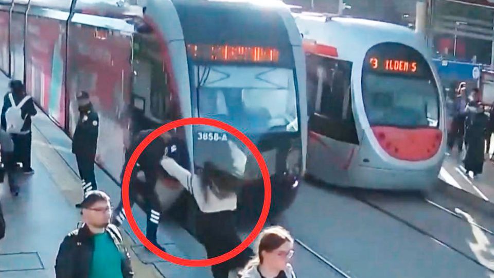 Unaufmerksame Frau läuft vor einfahrende Straßenbahn Unaufmerksame Frau läuft vor einfahrende Straßenbahn