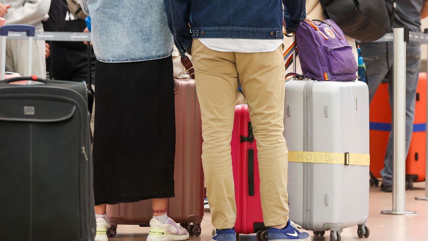 Reisende warten in einer Schlange am Flughafen Hamburg. Foto: Bodo Marks/dpa