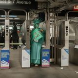 Eine Frau in der U-Bahn hat sich als Freiheitsstatue verkleidet