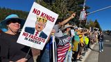 Eine Frau hält ein Trump-Plakat mit Hitler-Bärtchen in die Höhe