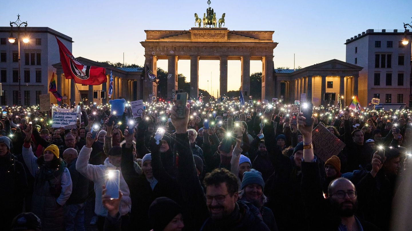 Hunderte Demonstranten bilden mit Smartphones und Feuerzeugen ein Lichtermeer. Foto: Annette Riedl/dpa